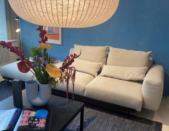Sofa in Beige mit Papierlampe und Blumenstrauß