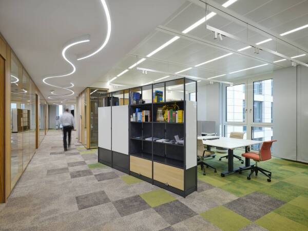 Arbeitswelten GVG Immobilien modernes Open Office mit höhenverstellbaren Schreibtischen und ergonomischen Bürostühlen sowie moderner Bürobeleuchtung